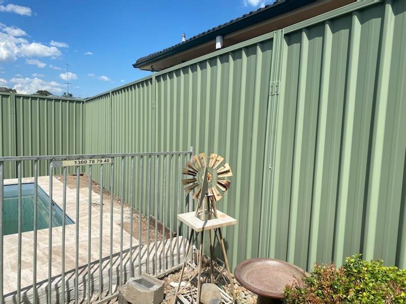 Dark metal fence above a retaining wall